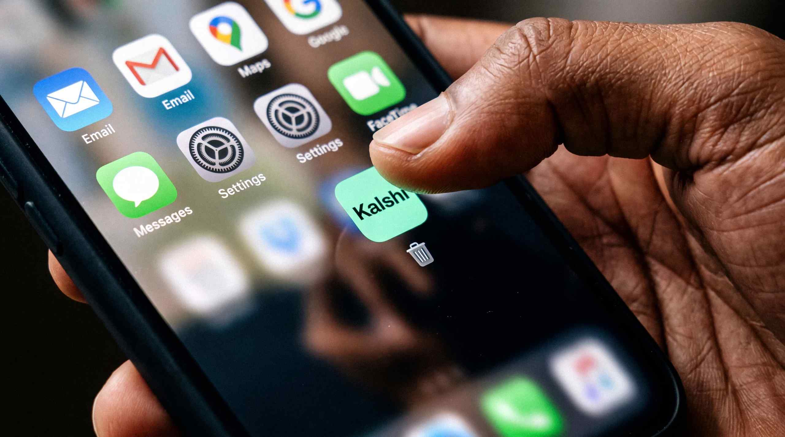 The Kalshi app on iPhone getting sent to trash.